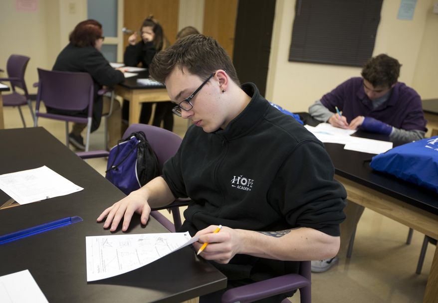 In this Monday, March 13, 2017 photo, Ian Lewis works on a math quiz during a class at Hope Academy in Indianapolis. The school is a tuition-free "recovery school" that use peer communities to support sobriety. (AP Photo/Michael Conroy)