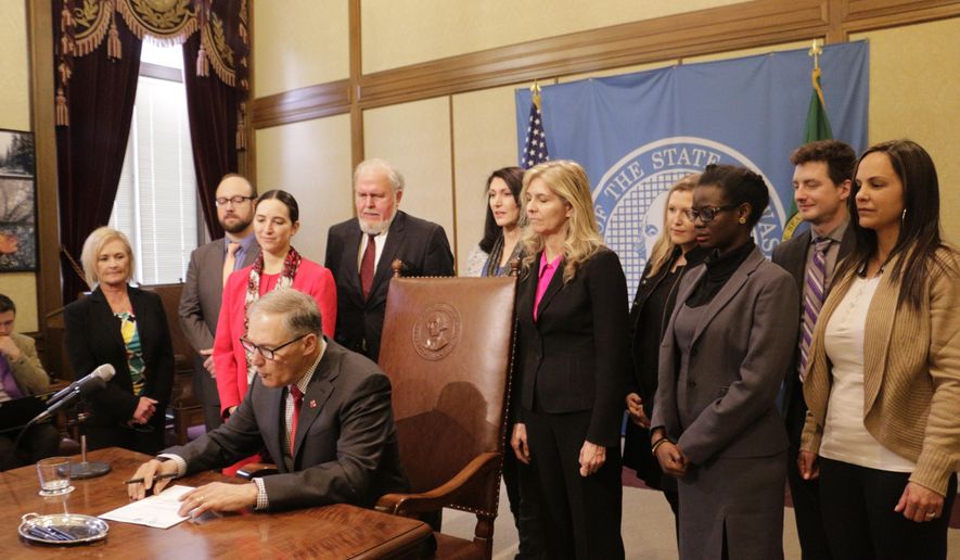 Washington Gov. Jay Inslee signs a measure to make it easier for victims of sex trafficking to vacate prostitution convictions, on Tuesday, April 25, 2017 in Olympia, Wash. Current law doesn't allow victims to vacate prostitution convictions if other crimes exist on their criminal record. (AP Photo/Rachel La Corte)