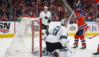 San Jose Sharks goalie Martin Jones kneels on the ice as Edmonton Oilers&#39; David Desharnais celebrates his game-winning goal during overtime of Game 5 of a first-round NHL hockey Stanley Cup playoff series, Thursday, April 20, 2017, in Edmonton, Alberta. The Oilers won 4-3. (Jeff McIntosh/The Canadian Press via AP)