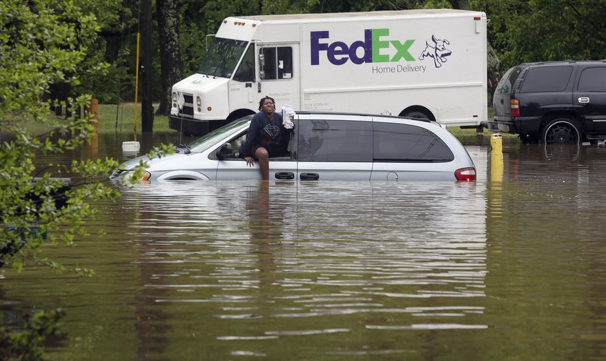 Jamesha Merritt exits a flooded vehicle in Raleigh, N.C., Tuesday, April 25, 2017. Storms have dumped several inches of rain on North Carolina's capital, prompting firefighters to rescue people from their vehicles and delaying school bus schedules. (AP Photo/Gerry Broome)