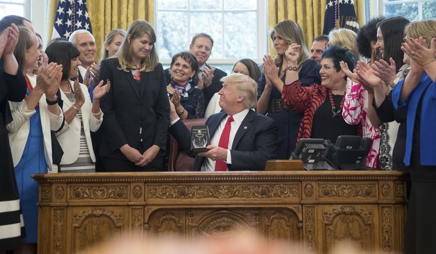 President Donald Trump, accompanied by Vice President Mike Pence, third from left, and first lady Melania Trump, center right, as he presents the 2017 National Teacher of the Year award to Codman Academy 9th grade humanities teacher Sydney Chaffee of Dorchester, Mass., center left, during a ceremony in the Oval Office at the White House in Washington, Wednesday, April 26, 2017. (AP Photo/Andrew Harnik)