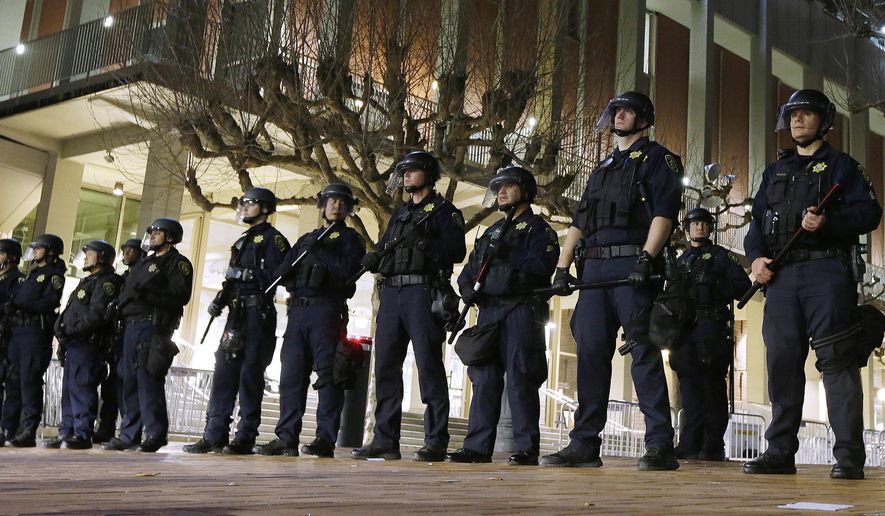 In this Feb. 1, 2017, file photo, University of California, Berkeley police guard the building where Breitbart News editor Milo Yiannopoulos was to speak in Berkeley, Calif. UC Berkeley police took a hands-off approach to protesters on the campus when violent rioters overtook a largely peaceful protest against a controversial speaker. After a series of protests around the country, some institutions are rethinking their security and tactics in an age of growing political polarization. (AP Photo/Ben Margot, File)
