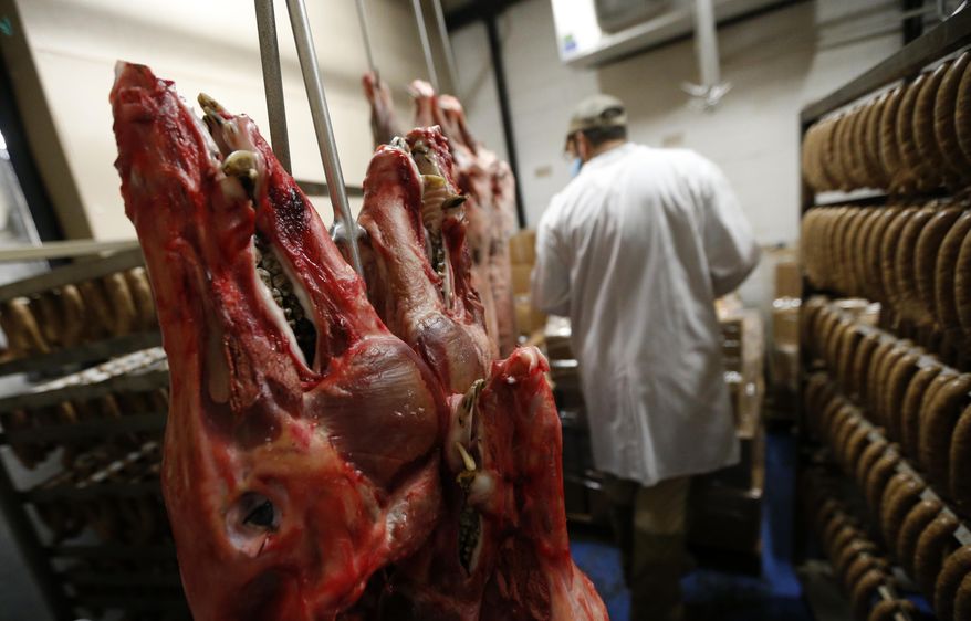 In this March 21, 2017 photo, wild boar heads hang next to racks of wild boar sausage at the Springfield Slaughterhouse in Springfield, La. The wild boar effort contrasts with one about 20 years ago to get nutria, an invasive rodent, on restaurant menus and grocery shelves. People love pork already, but the same cannot be said for nutria, which look a bit like rat-tailed beavers. (AP Photo/Gerald Herbert)
