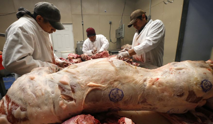 In this March 21, 2017 photo, workers butcher wild boar at the Springfield Slaughterhouse in Springfield, La. Area chefs praise its taste and have turned the meat into savory prosciutto, chorizo and meatballs. And this is a state that takes its food seriously, and has the James Beard awards to back it up. (AP Photo/Gerald Herbert)