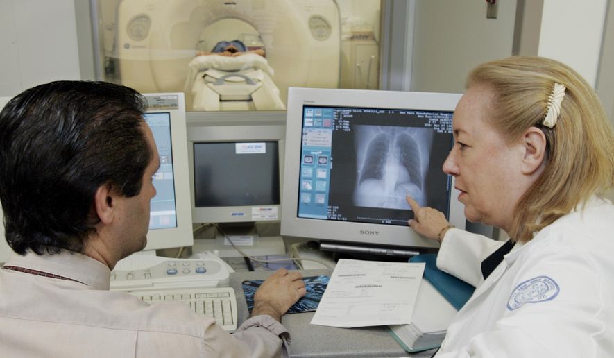 FILE - In this Friday, Aug. 12, 2005 file photo, Dr. Claudia Henschke, chief of the Division of Chest Imaging, right, and CT supervisor Gus Daphnis watch the lung scan of a patient at New York Hospital - Cornell Medical Center in New York. The test, called a spiral or helical CT scan, detects lung abnormalities as small as 5 millimeters, less than a fifth of an inch. In results published Wednesday, April 26, 2017 by Nature and the New England Journal of Medicine, researchers have taken an important step toward better lung cancer treatment. Using experimental tests that detect bits of DNA that tumors shed into the blood, they were able to track genetic changes in early-stage cases over time, and to find some recurrences up to a year before imaging scans could, giving a chance to try new therapy sooner. (AP Photo/Richard Drew)
