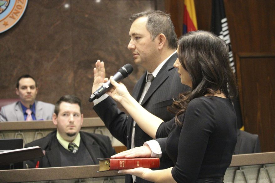 Peoria real estate broker and former city councilman, Ben Toma is sworn in as a member of the Arizona House of Representatives in Phoenix, Ariz., on Wednesday, April 26, 2017. His wife, Ana Toma, right, holds the Bible. Toma was picked from three nominees by the county Board of Supervisors to replace Republican Rep. Phil Lovas, who resigned to take a job with the Trump Administration. (AP Photo/Bob Christie)