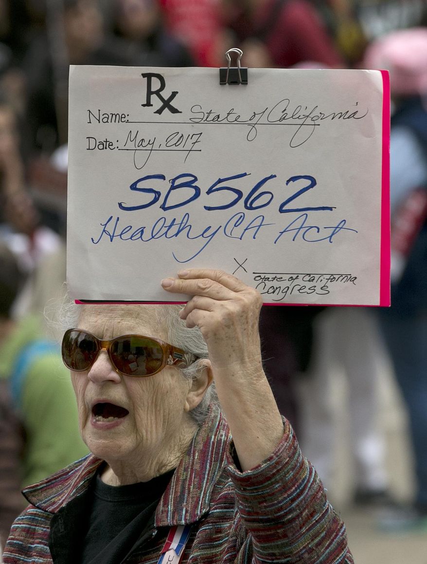Caroline Elam holds up a mock prescription order calling for passage of SB562, a single-payer health care bill, during a march to the Capitol, Wednesday, April 26, 2017, in Sacramento, Calif. The bill, by Democratic state Sens. Ricardo Lara, of Bell Gardens, and Toni Atkins, of San Diego, would guarantee health coverage with no out-of-pocket cost for all California residents, including people living in the country illegally is to be heard in the Senate Health Committee on Wednesday. (AP Photo/Rich Pedroncelli)