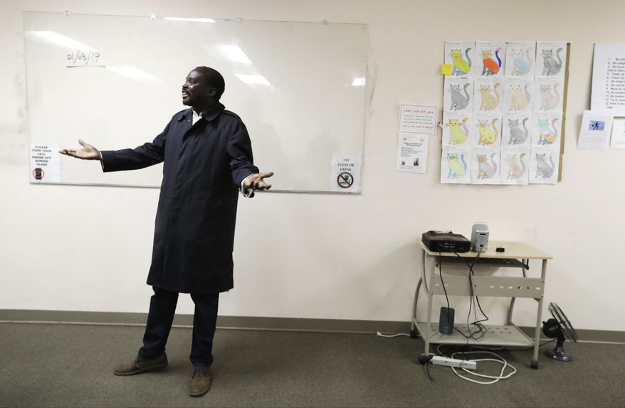 FILE - In this Wednesday, Jan. 4, 2017 file photo, Sudanese refugee Suliman Bandas, who teaches English as second language, speaks in his classroom in Lincoln, Neb. One hundred days into Donald Trump's presidency, The Associated Press asked people from across the country to write a letter to the president. He wrote: "I grew up in southern Sudan, which was engaged in a long civil war with the north. In 1986 my uncle ... took my father, a teacher, and other civilians in a helicopter to areas that needed aid. I watched from our backyard as that helicopter was shot down. ... In 2005, I was accepted to come to the U.S., a place where I can be safe and call home. ... In my job I help teach refugees, and every day they express to me their worries that this country may reject refugees in the months to come. I have heard you express concern about the Syrian people and I hope this is a turning point. Please, Mr. President, let America continue to treat refugees the same way God wanted them to be treated. That is what made America what it is _ strong and different from any other country on the face of the planet. The Bible says: "When a foreigner resides among you in your land, do not mistreat them. The foreigner residing among you must be treated as your native-born. ..." (Leviticus 19:33-34) Dear Mr. President, May God guide you, give you wisdom, and spirit of understanding in these very challenging moments." (AP Photo/Charlie Neibergall)