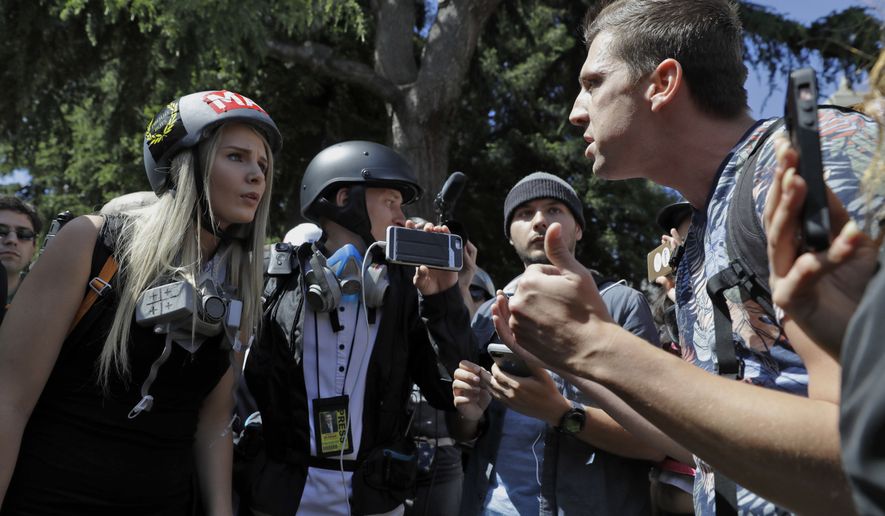 Demonstrators sharing opposing views argue during a rally Thursday, April 27, 2017, in Berkeley, Calif. Demonstrators gathered near the University of California, Berkeley campus amid a strong police presence and rallied to show support for free speech and condemn the views of Ann Coulter and her supporters. (AP Photo/Marcio Jose Sanchez)