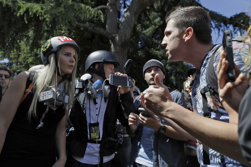Demonstrators sharing opposing views argue during a rally Thursday, April 27, 2017, in Berkeley, Calif. Demonstrators gathered near the University of California, Berkeley campus amid a strong police presence and rallied to show support for free speech and condemn the views of Ann Coulter and her supporters. (AP Photo/Marcio Jose Sanchez)