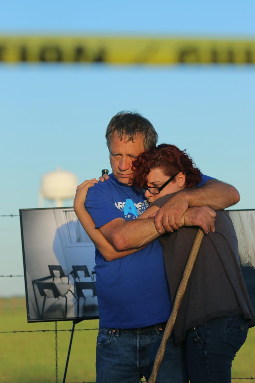 In this Monday, April 24, 2017 photo, anti-death penalty supporter Randy Gardner, left, embraces Gina Grimm, daughter of inmate Jack Jones, outside the Varner Unit near Varner, Ark. Jack Jones and Marcel Williams received lethal injections on the same gurney Monday night, just about three hours apart. It was the first double execution in the United States since 2000. (Stephen B. Thornton/The Arkansas Democrat-Gazette via AP)