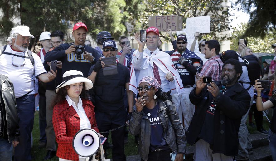 Demonstrators gather around a speaker Thursday, April 27, 2017, in Berkeley, Calif. Demonstrators gathered near the University of California, Berkeley campus amid a strong police presence and rallied to show support for free speech and condemn the views of Ann Coulter and her supporters. (AP Photo/Marcio Jose Sanchez)