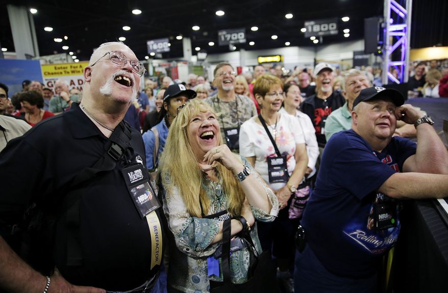 John, left, and Joe Windle, of Baltimore, watch on a television from the exhibition hall as President Donald Trump speaks at the National Rifle Association's annual convention in Atlanta, Friday, April 28, 2017. (AP Photo/David Goldman)
