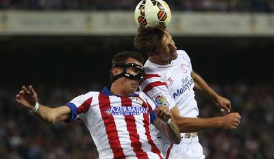 FILE - In this Saturday, Sept. 27, 2014 file photo, Atletico&#39;s Mario Mandzukic, left, in action Sevilla&#39;s Grzegorz Krychowiak, right, in between players during a Spanish La Liga soccer match between Sevilla and Atletico Madrid at the Vicente Calderon stadium in Madrid, Spain. The fight for third place has intensified again in the Spanish league, with Atletico Madrid and Sevilla looking to secure the final automatic spot for the Champions League next season (AP Photo/Andres Kudacki, File)