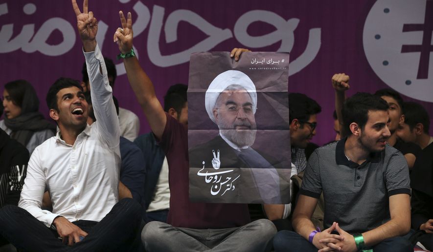 Pro-reform Iranian youths who support President Hassan Rouhani for the May 19 presidential election flash the victory sign as one of them holds Rouhani&#39;s poster in a campaign rally in Tehran, Iran, Saturday, April, 29, 2017. Rouhani, Iran&#39;s president since 2013, is running for a second term in office. (AP Photo/Vahid Salemi)
