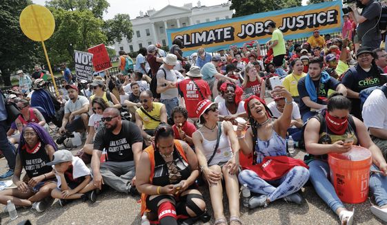 Demonstrators sit on the ground along Pennsylvania Ave. in front of the White House in Washington, Saturday, April 29, 2017, during a demonstration and march. Thousands of people gathered across the country to march in protest of President Donald Trump&#39;s environmental policies, which have included rolling back restrictions on mining, oil drilling and greenhouse gas emissions at coal-fired power plants. The demonstrators sat down for 100 seconds to mark President Trump&#39;s first 100 days in office. (AP Photo/Pablo Martinez Monsivais)