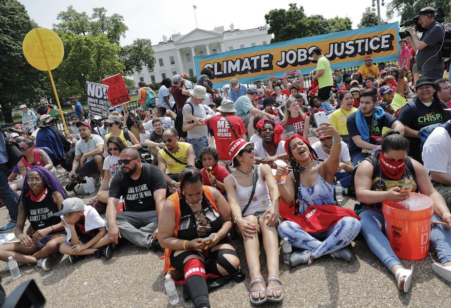 Demonstrators sit on the ground along Pennsylvania Ave. in front of the White House in Washington, Saturday, April 29, 2017, during a demonstration and march. Thousands of people gathered across the country to march in protest of President Donald Trump&#x27;s environmental policies, which have included rolling back restrictions on mining, oil drilling and greenhouse gas emissions at coal-fired power plants. The demonstrators sat down for 100 seconds to mark President Trump&#x27;s first 100 days in office. (AP Photo/Pablo Martinez Monsivais)
