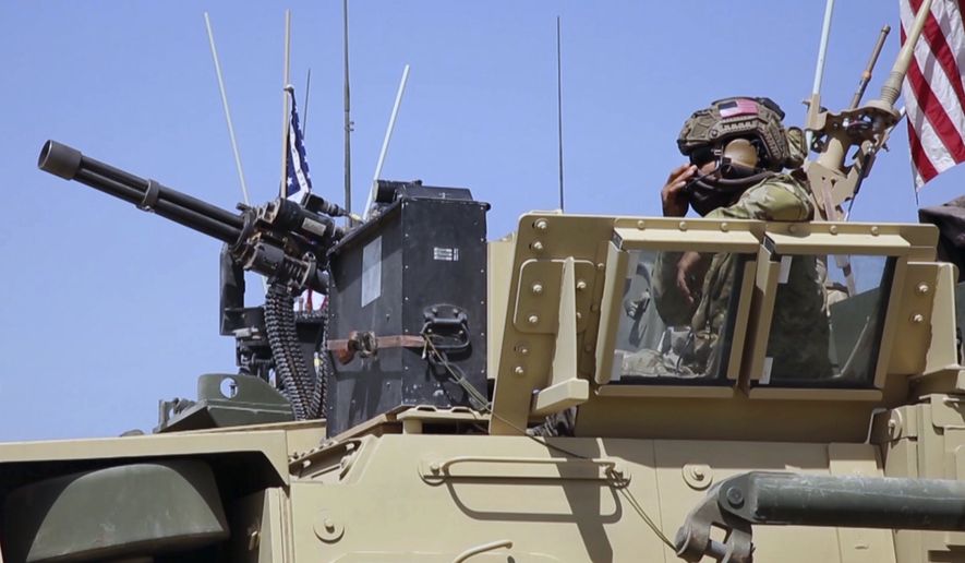 This Saturday, April. 29, 2017 still taken from video, shows an American soldier looking out of an armored vehicle in the northern village of Darbasiyah, Syria. U.S. moved troops and armored vehicles through several Syrian cities and towns on Friday and Saturday in a show of force apparently intended to dissuade Turkey and Syrian Kurdish forces from attacking each other. (AP Photo via APTV)