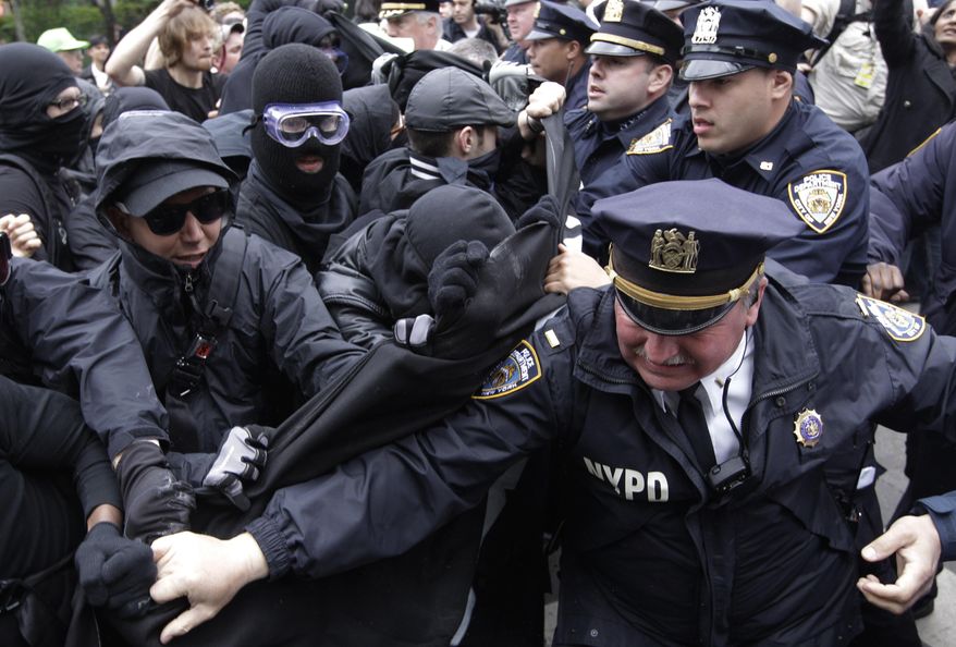 FILE - In this Tuesday, May 1, 2012, file photo, police officers and protesters scuffle, in New York. Tens of thousands of immigrants and their supporters are expected to rally Monday, May 1, 2017, against Trump administration policies. While immigration reform has been a key focus of May 1 demonstrations in the U.S. for over a decade, the roots of May Day, or International Workers Day, stretch back over a century. (AP Photo/Mary Altaffer, File)