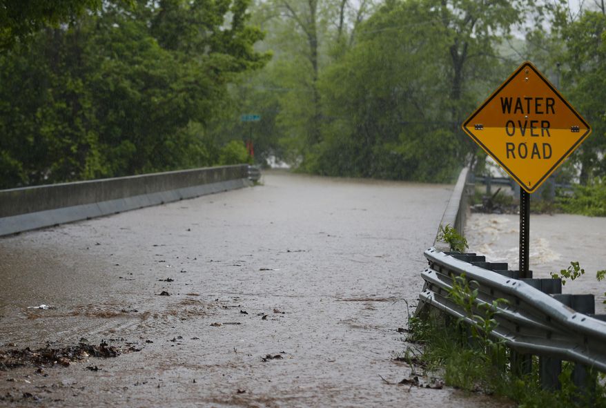 Water begins to cover the Kinser Bridge on Farm Road 164 on Saturday, April 29, 2017, in Springfield, Mo. Missouri Governor Eric Greitens has declared a state of emergency because of flooding across southern Missouri. (Nathan Papes/The Springfield News-Leader via AP)