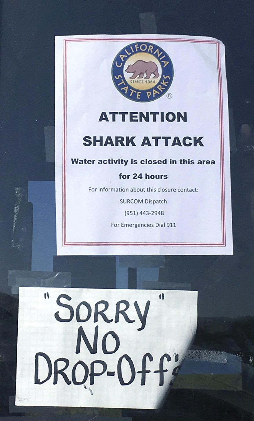 In this Sunday, April 30, 2017 photo, a sign warns beach goers at San Onofre State Beach after a woman was attacked by a shark in the area Saturday, along the Camp Pendleton Marine base in San Diego County, Calif. The beach remained closed Sunday. (Laylan Connelly/The Orange County Register via AP)