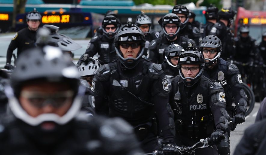 Seattle Police Officers stage near a May Day protest, Monday, May 1, 2017, in Seattle.  Immigrant and union groups marched in cities across the United States on Monday, to mark May Day and protest against President Donald Trump&#39;s efforts to boost deportations. The day has become a rallying point for immigrants in the U.S. since demonstrations were held in 2006 against a proposed immigration enforcement bill. (AP Photo/Ted S. Warren)