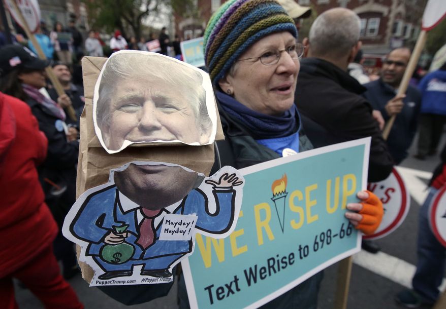 Nancy Kohn, of Boston, holds a Donald Trump puppet and a placard during a May Day rally, Monday, May 1, 2017, in Chelsea, Mass. Thousands of people chanted, picketed and marched on cities across America on Monday as May Day demonstrations raged against President Donald Trump&#39;s immigration policies. (AP Photo/Steven Senne)