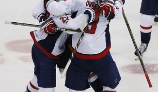 Washington Capitals&#x27; Kevin Shattenkirk (22) celebrates with Dmitry Orlov (9), and Alex Ovechkin (8) after score the game-winning goal in overtime of Game 3 in an NHL Stanley Cup Eastern Conference semifinal hockey game against the Pittsburgh Penguins in Pittsburgh, Monday, May 1, 2017. The Capitals won 3-2. (AP Photo/Gene J. Puskar)