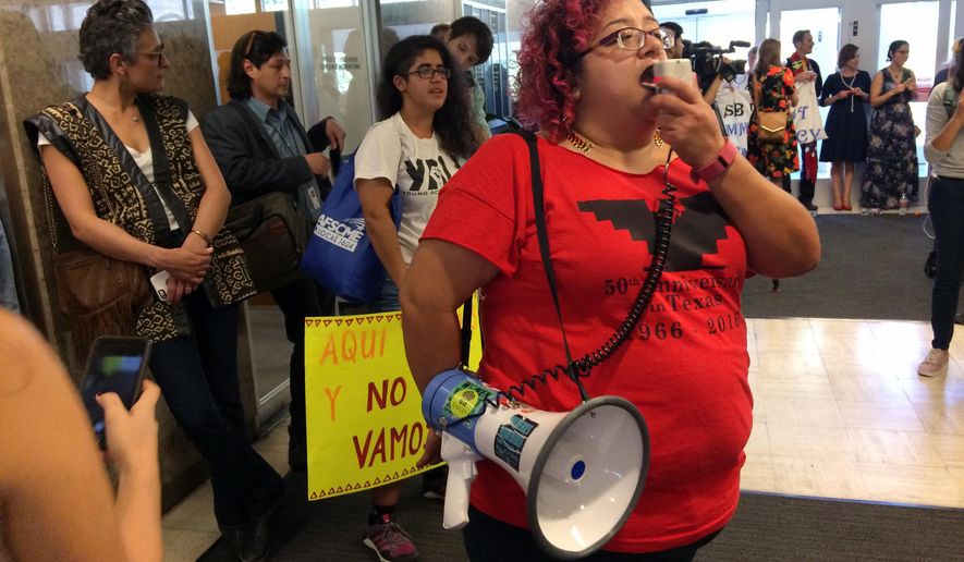 Immigrant rights activist Barbie Hurtado leads protesters chanting during a sit-in at the Texas Department of Insurance building in Austin, Texas on Monday, May 1, 2017. The protesters, opposing proposed Texas legislation that would compel police to enforce federal immigration laws, vow to occupy the building until Republican Gov. Greg Abbott vetoes the bill. (AP Photo/Meredith Hoffman)