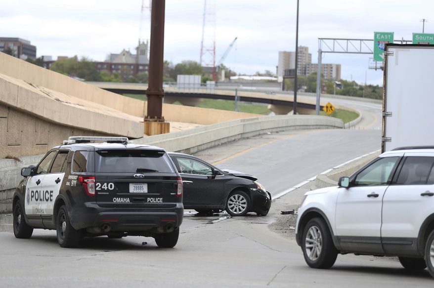 Omaha Police investigate the scene of a car wreck following a police persuit on I-480 eastbound Monday, May 1, 2017, in Omaha, Neb. An inmate who escaped from the Pottawattamie County jail in Council Bluffs, Iowa, and carjacked a Nissan Sentra, Monday, May 1, 2017, in Omaha, Neb. was captured after crashing the stolen vehicle during a police chase in neighboring Nebraska. (Rebecca Gratz/Omaha World-Herald via AP)