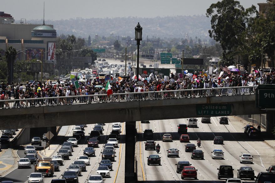 Thousands of protesters march over the 110 Freeway during a May Day rally Monday, May 1, 2017, in Los Angeles. (AP Photo/Jae C. Hong)