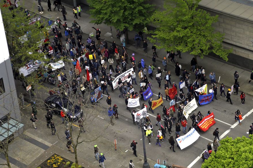Protesters march through the street in Portland, Ore., Monday, May 1, 2017. Several thousand protestors marched through downtown, disrupting traffic. Immigrant and union groups will march in cities across the United States to mark May Day and protest against President Donald Trump's efforts to boost deportations. (AP Photo/Don Ryan)