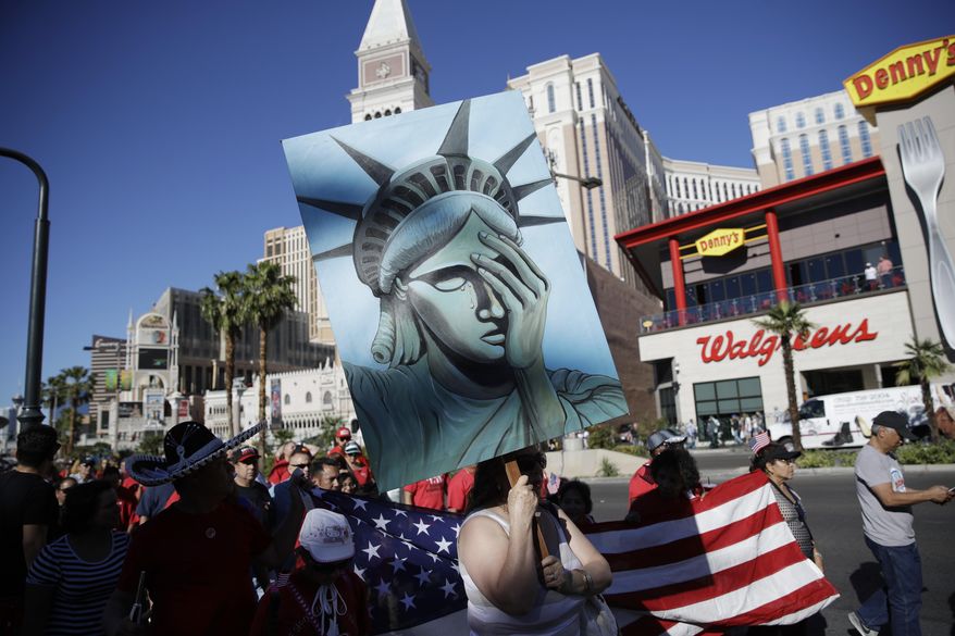 People walk along the Las Vegas Strip during a May Day march, Monday, May 1, 2017, in Las Vegas. Union members and activists marched along and near the Las Vegas Strip to highlight immigration issues and push back against Trump administration policies. (AP Photo/John Locher)