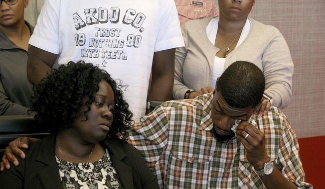 Odell Edwards wipes away tears as he sits with his wife, Charmaine Edwards, listening to their attorney Lee Merritt talking about the death of their son, Jordan Edwards, in a police shooting Saturday in Balch Springs, Texas, in Merritt&#x27;s law office in Dallas, Monday, May 1, 2017. A suburban Dallas police chief said Monday that his department wrongly described why an officer fired into a moving vehicle and killed Jordan Edwards, after an attorney for the boy’s family said officers were trying to “justify the unjustifiable.” (Guy Reynolds/The Dallas Morning News via AP)