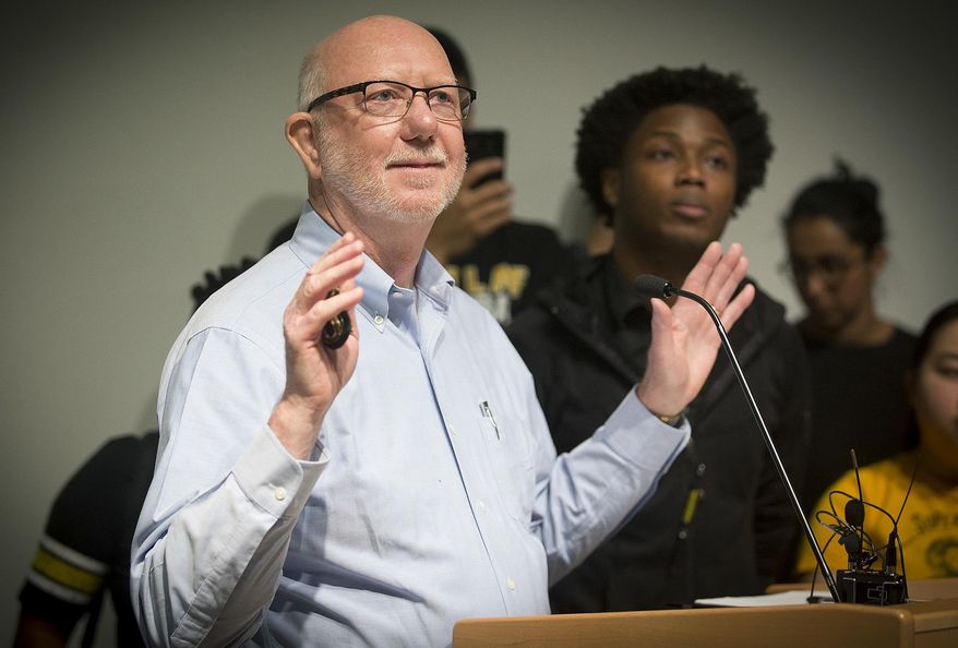 St. Olaf College President David R. Anderson is surrounded by students in the Tomson Hall auditorium who were demanding action and dialogue after numerous acts of incidents of racial hate on campus, Monday, May 1, 2017 in Northfield, Minn. Hundreds of students boycotted classes at St. Olaf College on Monday, instead packing an administration building to protest a rash of racist and threatening messages left around campus. (Elizabeth Flores/Star Tribune via AP)