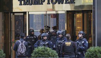 New York City Police Department officers stand at the front entrance of Trump Tower in New York. The new federal spending bill would allocate $61 million to reimburse primarily New York City and Palm Beach County for police overtime and other local expenses related to securing President Donald Trump and his family at Trump Tower and Mar-a-Lago. (AP Photo/Seth Wenig, File)