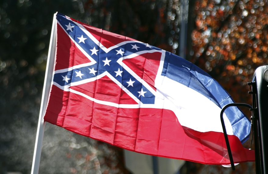 FILE - In this Tuesday, Jan. 19, 2016 file photo, a state flag of Mississippi is unfurled by Sons of Confederate Veterans and other groups on the grounds of the state Capitol in Jackson, Miss., in support of keeping the Confederate battle emblem on the state flag. Some black Mississippi officials say they are boycotting a regional legislative meeting that their own state is hosting, which meets July 29-Aug. 2, 2017, in Biloxi, to protest the Confederate battle emblem on the state flag. (AP Photo/Rogelio V. Solis, File)