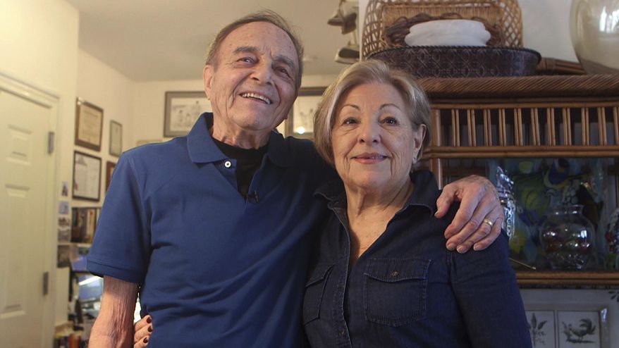 In this image taken from video on April 5, 2017, Nathan Zaccaria and his wife Fran Zaccaria pase in their home in Long Branch, N.J. Nathan Zaccaria has introduced a case that fits over smartphones and keeps out the glare so that consumers can see the screens outdoors. (Brian Johnston/The Asbury Park Press via AP)