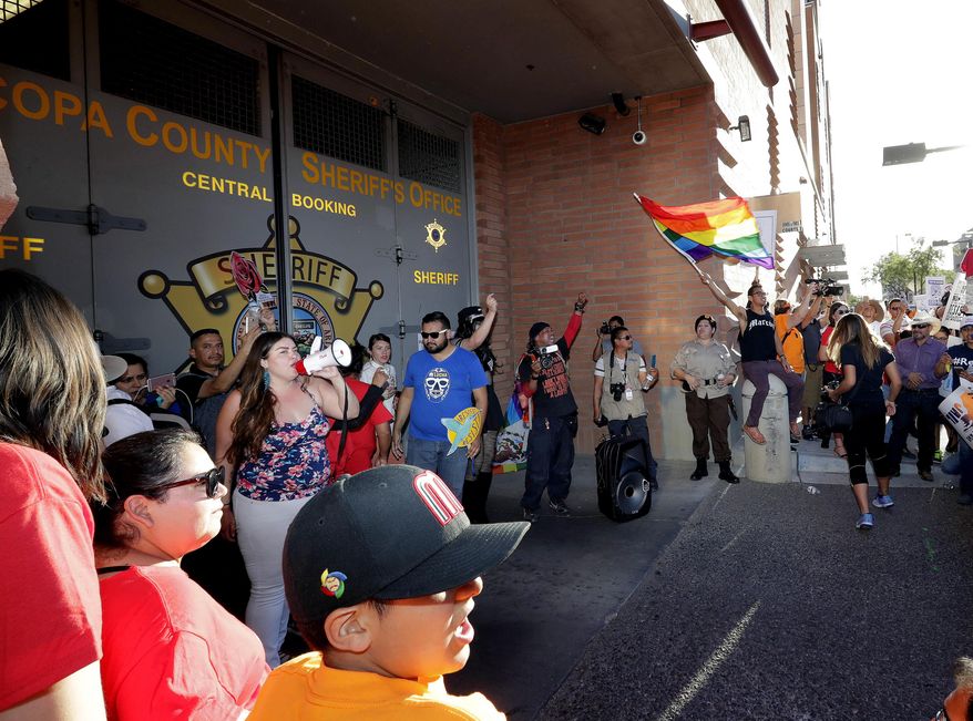 Protesters stand at the entrance to the Maricopa County Jail, Monday, May 1, 2017 in Phoenix. Immigrant and union groups marched in cities across the United States on Monday to mark May Day and protest against President Donald Trump's efforts to boost deportations. The day has become a rallying point for immigrants in the U.S. since demonstrations were held in 2006 against a proposed immigration enforcement bill. (AP Photo/Matt York)