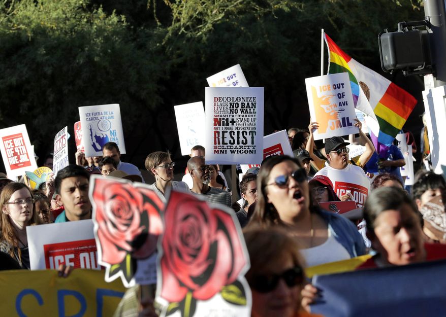 Protesters march through downtown Phoenix, Monday, May 1, 2017. Immigrant and union groups marched in cities across the United States on Monday to mark May Day and protest against President Donald Trump's efforts to boost deportations. The day has become a rallying point for immigrants in the U.S. since demonstrations were held in 2006 against a proposed immigration enforcement bill. (AP Photo/Matt York)