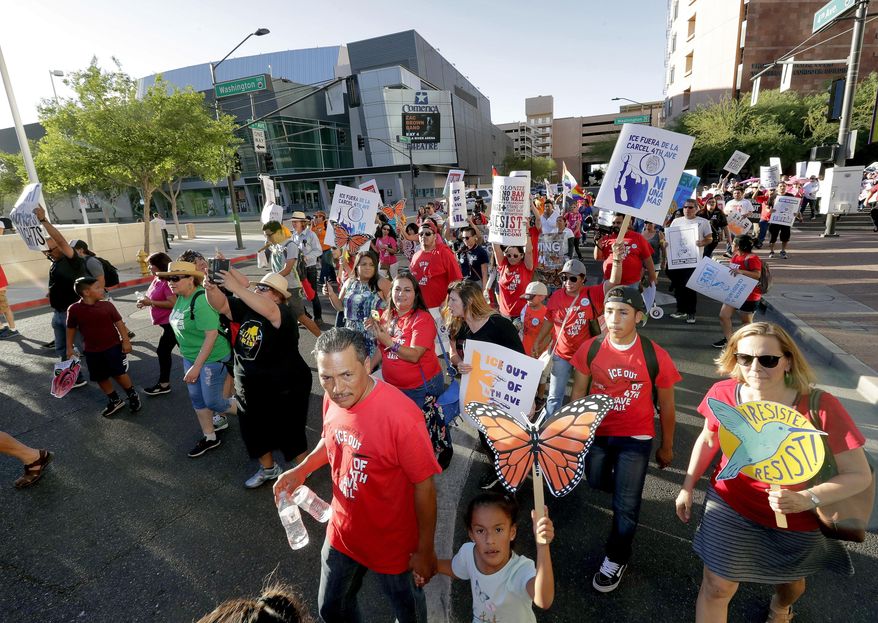 Protesters march through downtown Phoenix, Monday, May 1, 2017. Immigrant and union groups marched in cities across the United States on Monday to mark May Day and protest against President Donald Trump's efforts to boost deportations. The day has become a rallying point for immigrants in the U.S. since demonstrations were held in 2006 against a proposed immigration enforcement bill. (AP Photo/Matt York)