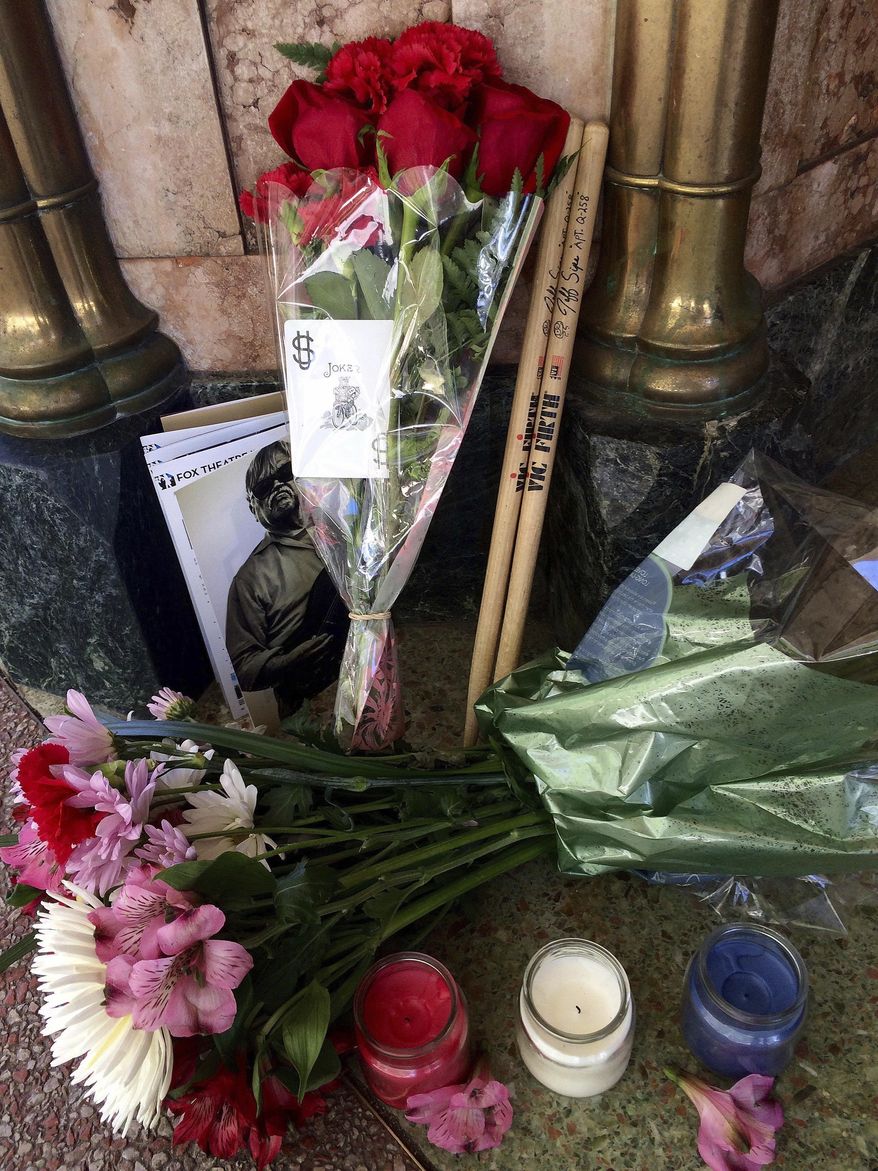 Candles, flowers, a pair of drum sticks and other mementoes are left Tuesday at the entrance to the Fox Theatre as a memorial to Bruce Hampton. (AP Photo/Jeff Martin)