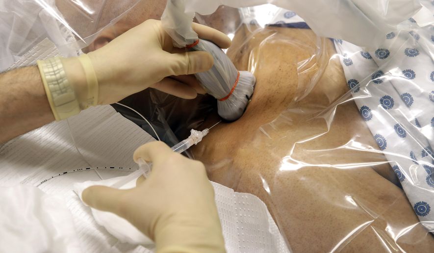 In this photo taken Feb. 15, 2017, anesthesiologist Dr. Ron Samet performs an ultrasound-guided nerve block at the University of Maryland Medical Center. Bathing the nerves responsible for certain types of pain in a numbing drug allows many patients to avoid or reduce use of potentially addictive painkillers after surgery, one way hospitals are reducing their own dependence on opioids. (AP Photo/Patrick Semansky)