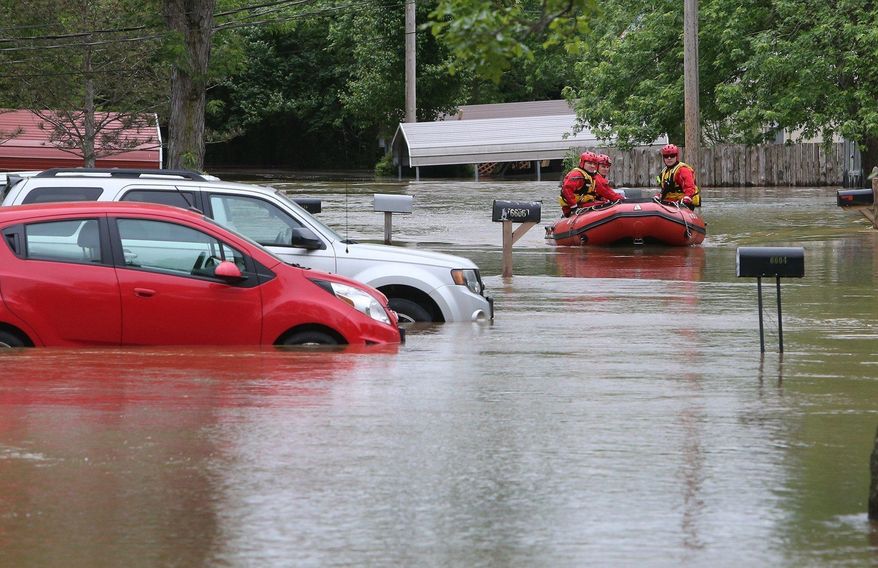 Members of the High Ridge fire department take a boat in at the Village Green Estates trailer park on Monday, May 1, 2017, in Cedar Hill, Mo. Torrential rains over the weekend caused flash flooding across Missouri, and as storm drains and fields continue to pour into rivers, they continue to rise. (J.B. Forbes/St. Louis Post-Dispatch via AP)