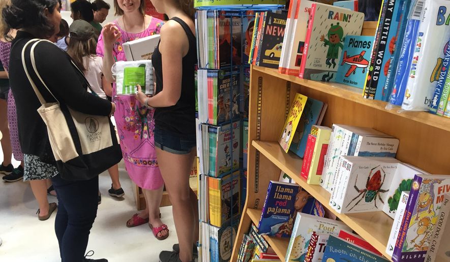 In this April 29, 2017 photo, Author Emma Straub, center, chats with customers on the opening day for the new Books are Magic bookstore in Brooklyn, New York, which she owns with her husband. They decided to open the store after another beloved neighborhood bookstore closed. Straub is one of a number of authors who own bookstores around the country, including Ann Patchett and Jeff Kinney. (AP Photo/Beth J. Harpaz)
