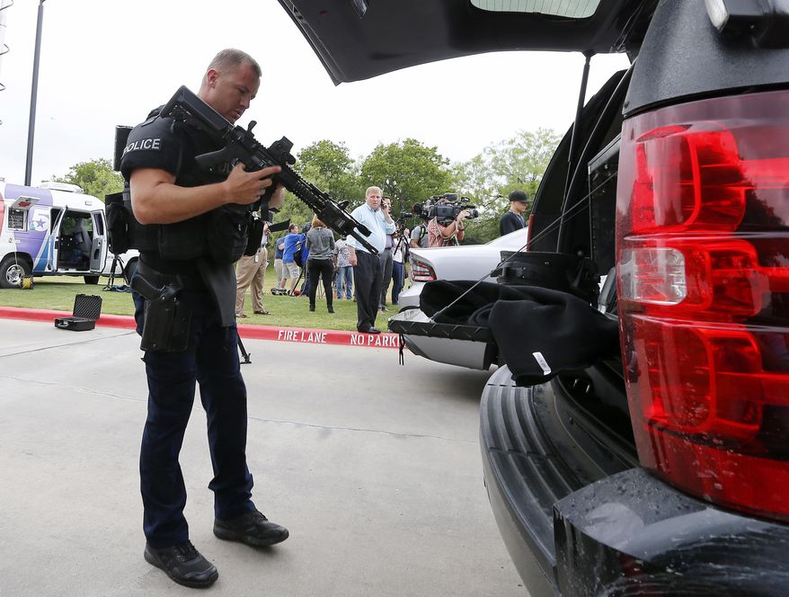 An Irving police officer checks his rifle as he arrives at a fatal shooting scene on the North Lake College campus in Irving, Texas, Wednesday, May 3, 2017. The situation prompted a lockdown at the school in the Dallas suburb. (Jae S. Lee/The Dallas Morning News via AP)