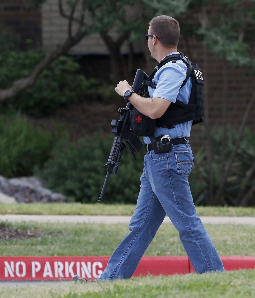 An officer works at a shooting scene on the North Lake College campus in Irving, Texas, Wednesday, May 3, 2017. The situation prompted a lockdown at the school in the Dallas suburb. (Jae S. Lee/The Dallas Morning News via AP)