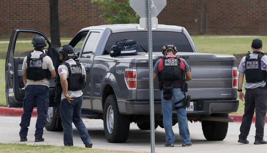 U.S. Customs and Border Protection officers work at a shooting scene on the North Lake College campus in Irving, Texas, Wednesday, May 3, 2017. The situation prompted a lockdown at the school in the Dallas suburb. (Jae S. Lee/The Dallas Morning News via AP)