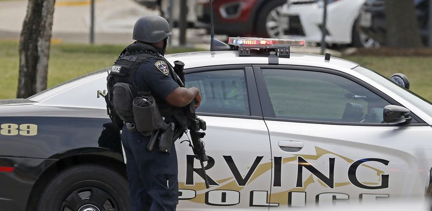 An officer works at a shooting scene on the North Lake College campus in Irving, Texas, Wednesday, May 3, 2017. The situation prompted a lockdown at the school in the Dallas suburb. (Jae S. Lee/The Dallas Morning News via AP)