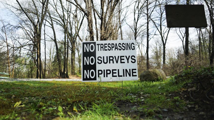 In this April 20, 2017 photo, a sign opposing a proposed pipeline sits in the front yard of a house in Green, Ohio. The town has hired a law firm to stop the pipeline from being built through the community. (AP Photo/Dake Kang)